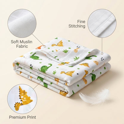 Folded baby blanket with dinosaur pattern on a beige background, showing soft muslin fabric, fine stitching, and premium print details.